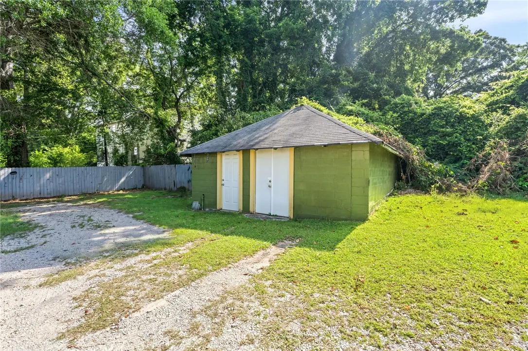 A detached structure with ample potential, set on a verdant lot with mature foliage.