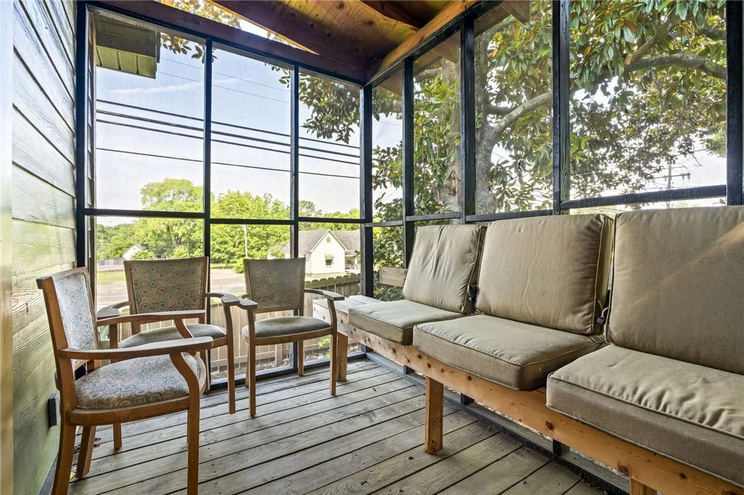 A screened porch with a durable wood floor invites relaxation amidst verdant outdoor views.
