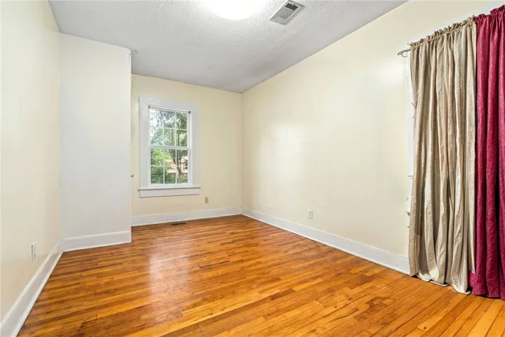 Natural light pours into this space, illuminating the rich, polished hardwood flooring.