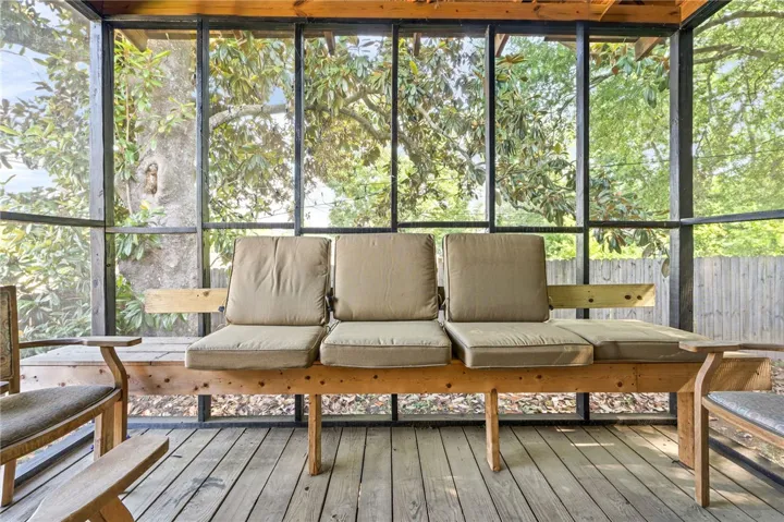 Enjoy the peaceful surroundings from this inviting screened porch, ideal for relaxation.
