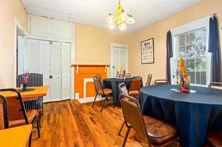 Authentic wood floors and an artistic orange mantel enhance this vibrant dining area.