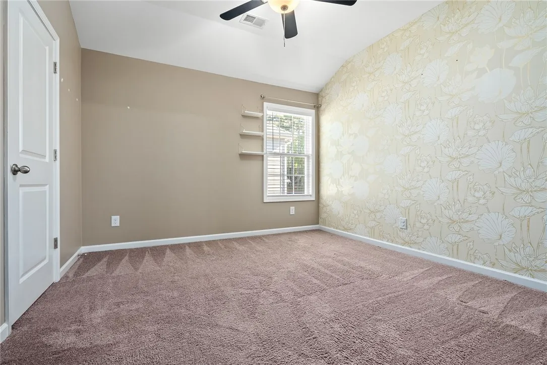 A restful chamber offers sloped ceilings and ample natural light, ideal for peaceful slumber.