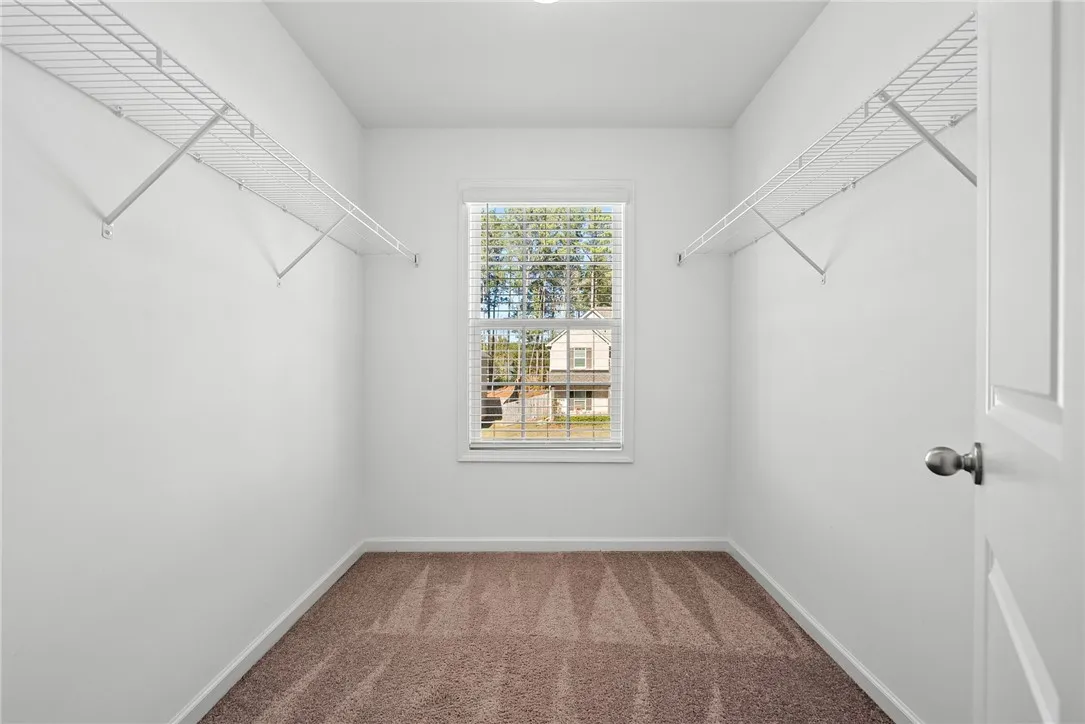A well-organized walk-in closet with ample shelving and natural light.