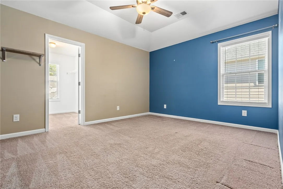 A quiet retreat, this bedroom offers plush carpet and a convenient walk-in closet.