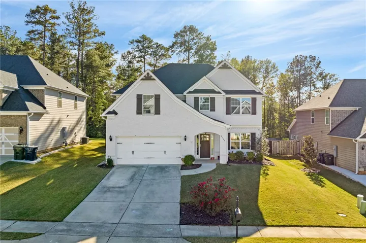A classic facade with a welcoming arched entryway and neat landscaping invites you into this charming home.