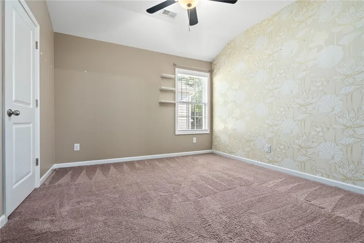 A restful chamber offers sloped ceilings and ample natural light, ideal for peaceful slumber.