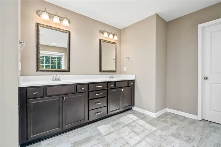 Dual vanities with ample storage enhance this well-appointed primary bathroom.