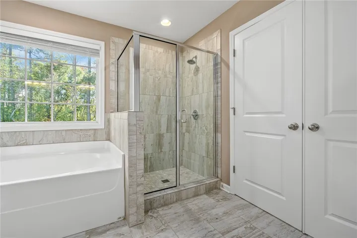 Luxurious bathroom with a spacious soaking tub and a sleek glass-enclosed shower.