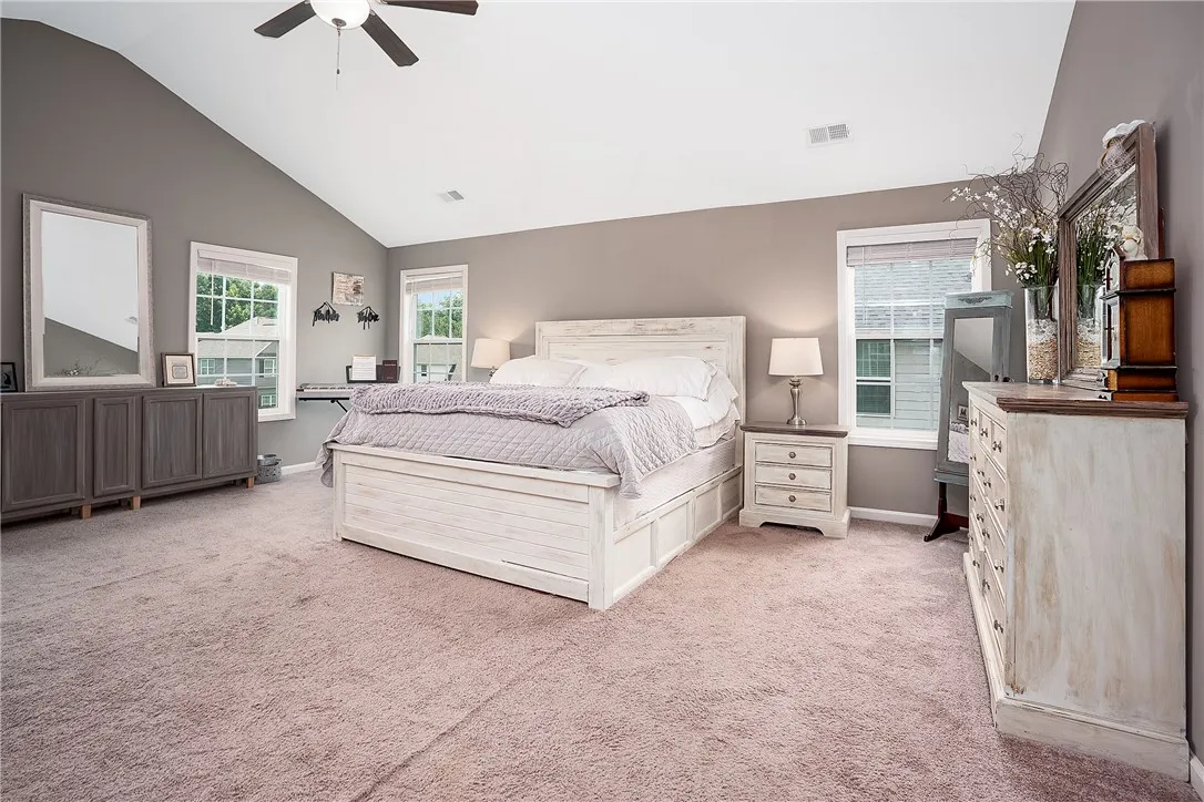 Relax in this well-appointed sleeping area with a vaulted ceiling and soft carpeting.