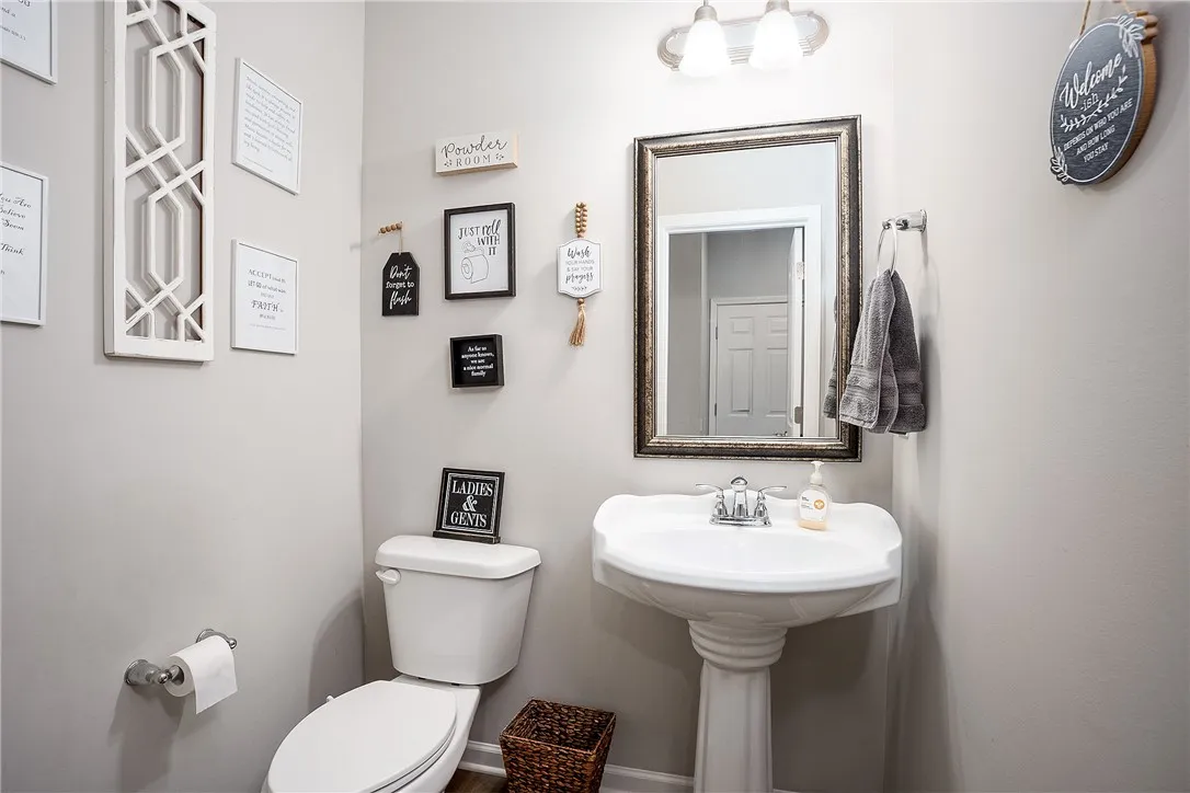 A well-appointed powder room features a pedestal sink and stylish framed mirror.