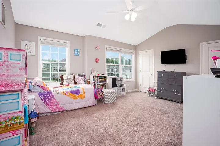 A well-lit bedroom provides ample natural light through multiple windows, perfect for comfortable living.