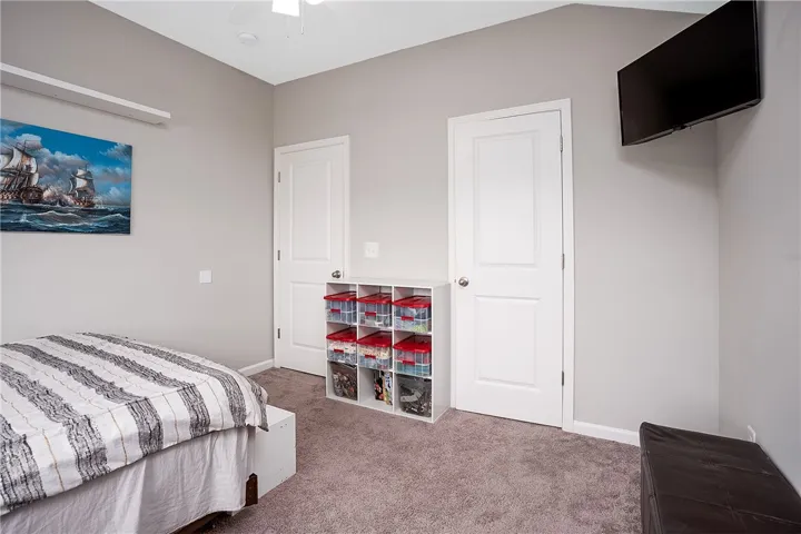 Comfortable bedroom features carpeted floors and a practical ceiling fan.