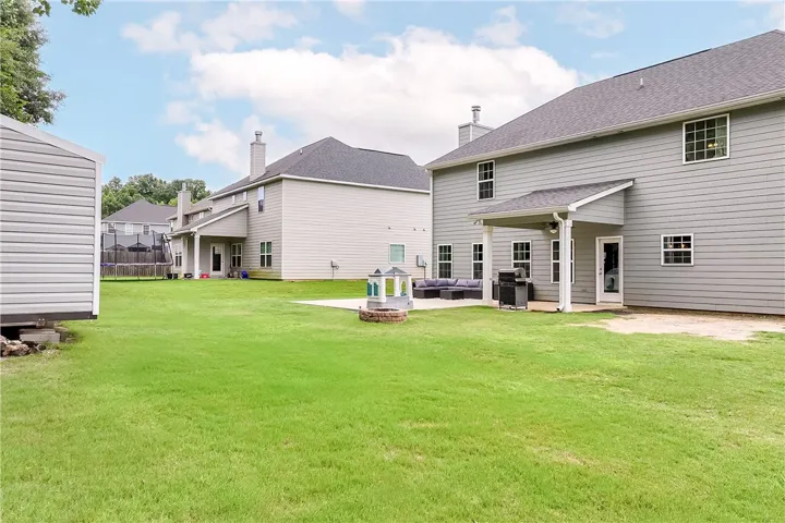 A spacious backyard with an inviting patio offers ample room for outdoor activities and relaxation.