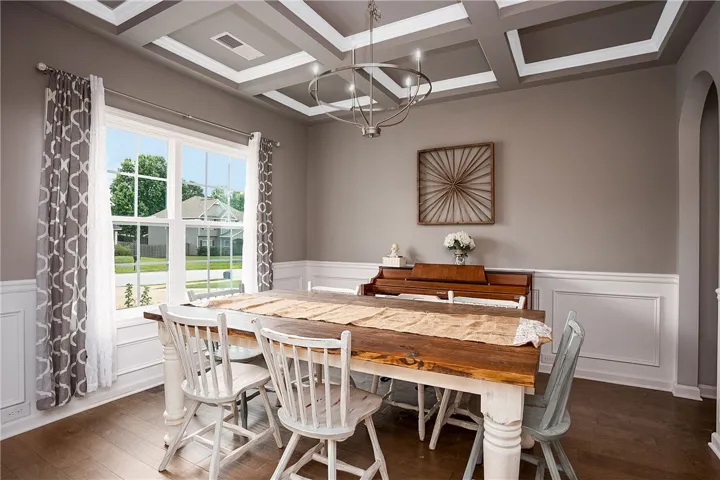 Elegant coffered ceilings crown this formal dining area, featuring classic wainscoting and warm wood​​‌​​​​‌​​‌‌​‌‌​​​‌‌​‌​‌​‌​​​‌​​ flooring.