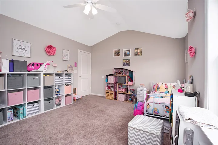 This spacious bedroom offers high vaulted ceilings and plush carpeting, creating a comfortable and airy retreat.