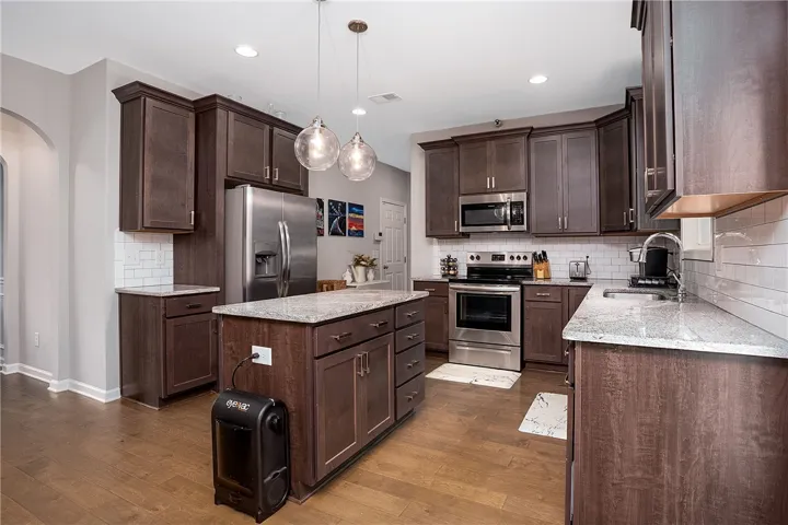 A well-appointed kitchen features rich cabinetry, lustrous granite counters, and modern stainless steel appliances.