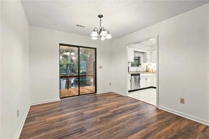 Dining/bkfst room w/ double doors leading to back deck & screened porch.  Eating space leads to kitchen