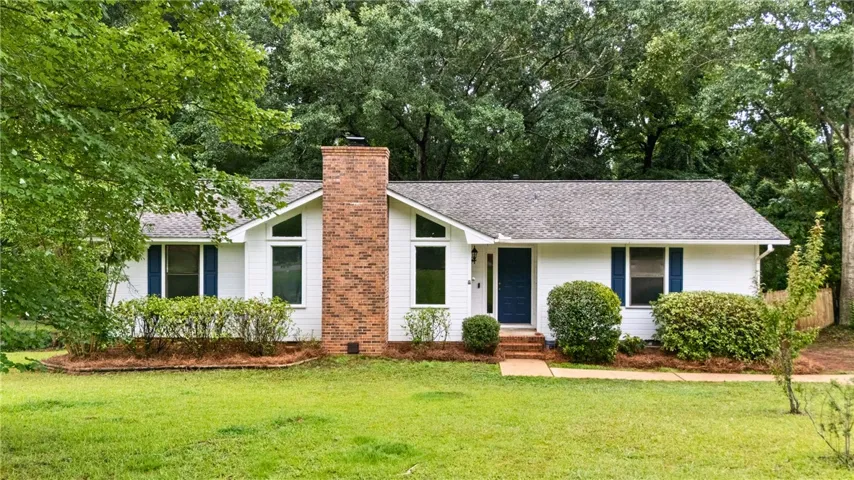Single-level residence featuring a prominent brick chimney & Brand New Roof!