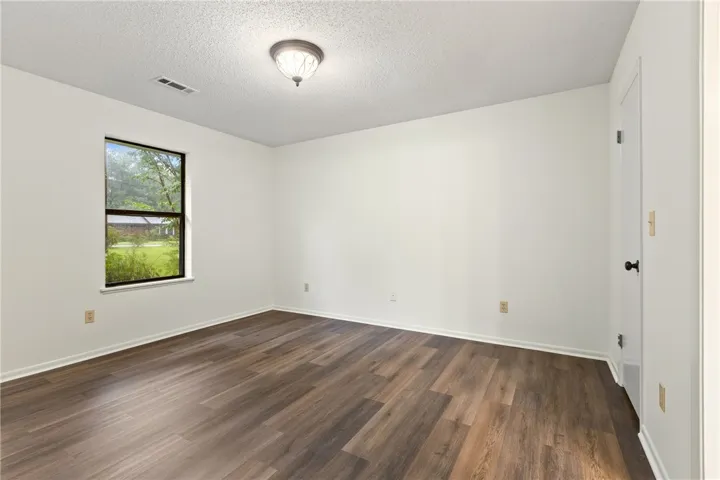 Primary bedroom features new LVP flooring, large walk in closet & en suite.
