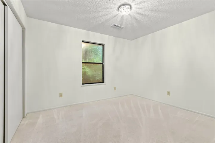 Guest bedroom over looks the wooded backyard.  Large double door closet.