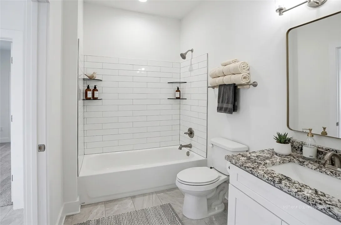 A well-lit bathroom features a deep soaking tub and a sleek vanity with ample counter space.