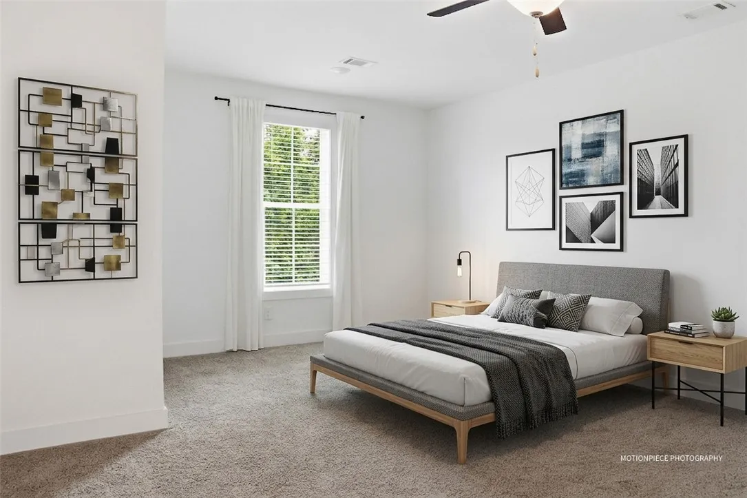 A quiet retreat, this primary bedroom offers soft carpeting and a window with natural light.