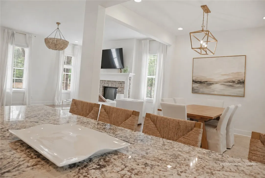 Granite counters and recessed lighting elevate this open-concept kitchen and dining area.