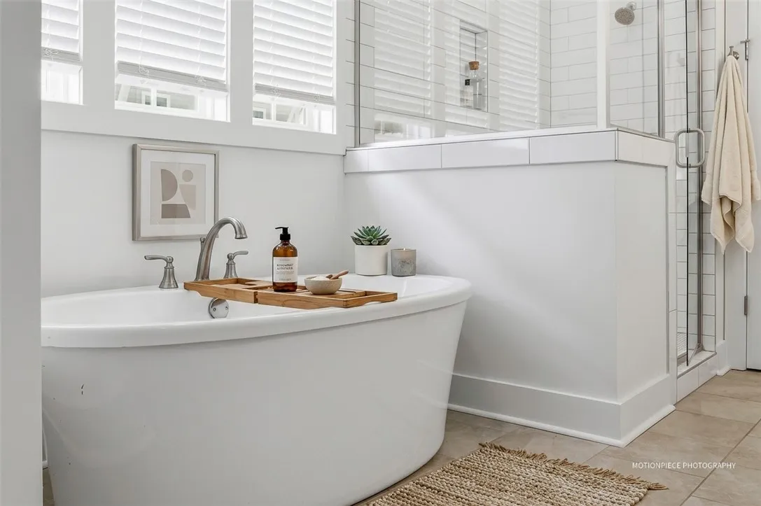 Unwind in a luxurious soaking tub, complemented by a glass-enclosed shower in this serene bathroom retreat.