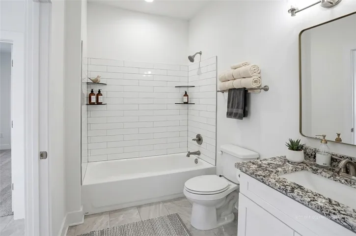 A well-lit bathroom features a deep soaking tub and a sleek vanity with ample counter space.