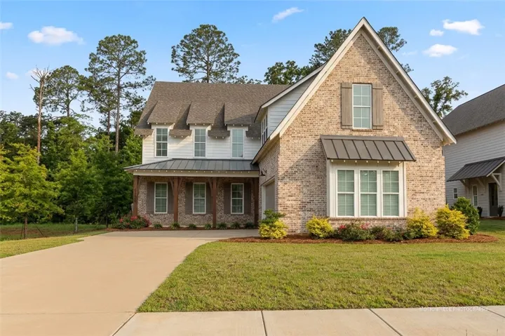 Crafted from brick and siding, this charming home features a welcoming covered porch.
