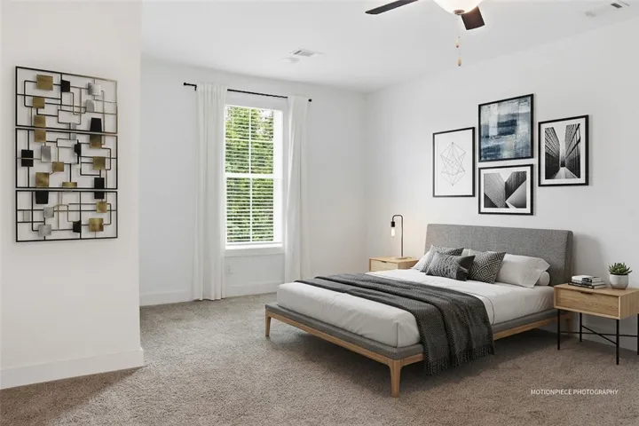 A quiet retreat, this primary bedroom offers soft carpeting and a window with natural light.