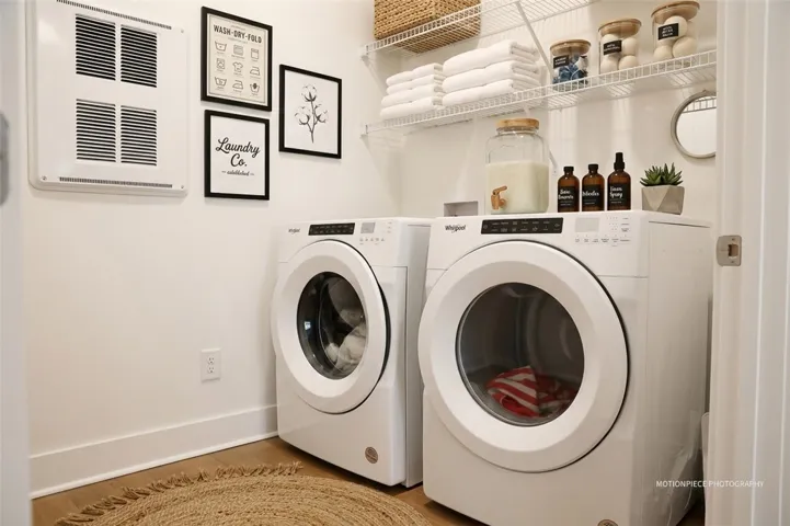 Functional laundry room featuring a washer and dryer, complete with overhead shelving for practical storage.