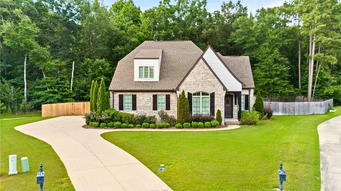 A well-manicured lawn and elegant brick facade create inviting curb appeal for this charming residence.