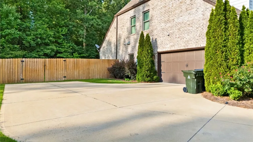 A durable concrete driveway leads to a brick residence, offering practical parking and direct garage access.