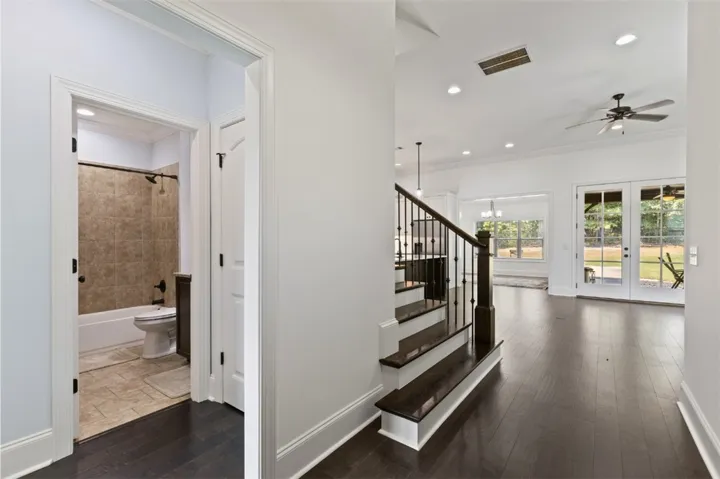 Rich hardwood floors welcome you into this elegant open-concept living space, with an adjacent bath and access to the outdoor area.
