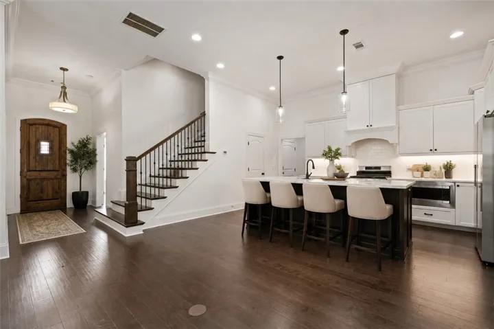 A spacious, open-concept interior featuring rich hardwood floors and a modern kitchen island with bar seating.