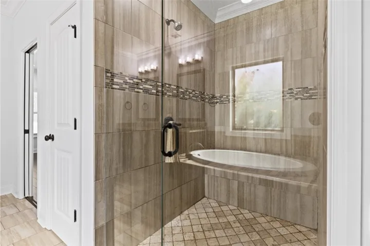 A glass-enclosed shower and separate soaking tub create a luxurious bathing sanctuary.