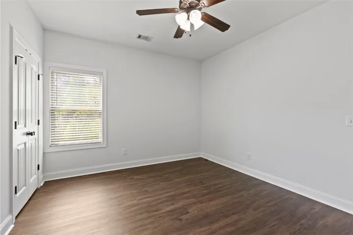 A well-proportioned interior space offers a harmonious blend of classic dark wood flooring and pristine white walls.