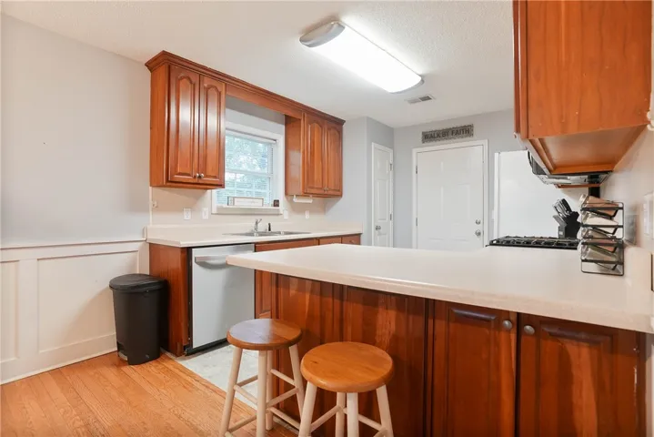A warm and inviting kitchen showcases rich cabinetry and practical counter space, perfect for culinary endeavors.