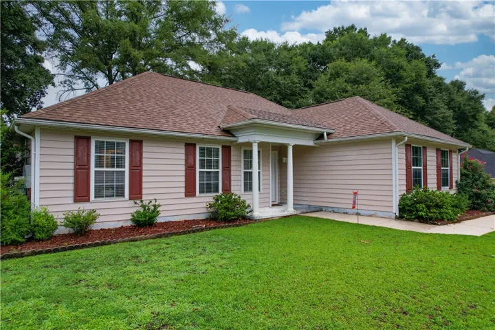 A well-maintained facade with inviting porch and lush green landscaping.