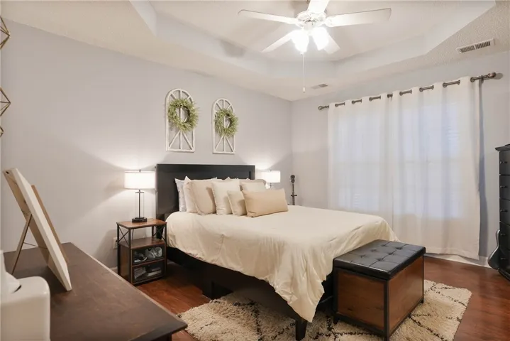 Recessed lighting and a ceiling fan illuminate this inviting, well-appointed bedroom.