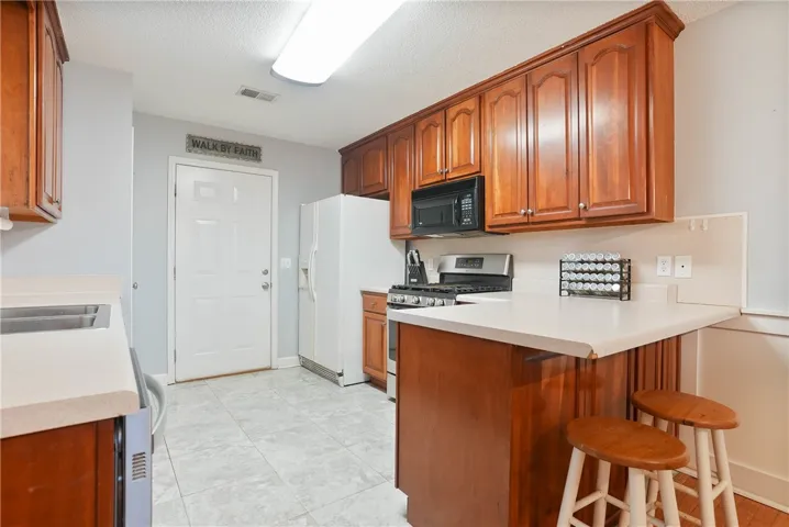 Functional kitchen with ample cabinet space, a breakfast bar, and essential appliances.