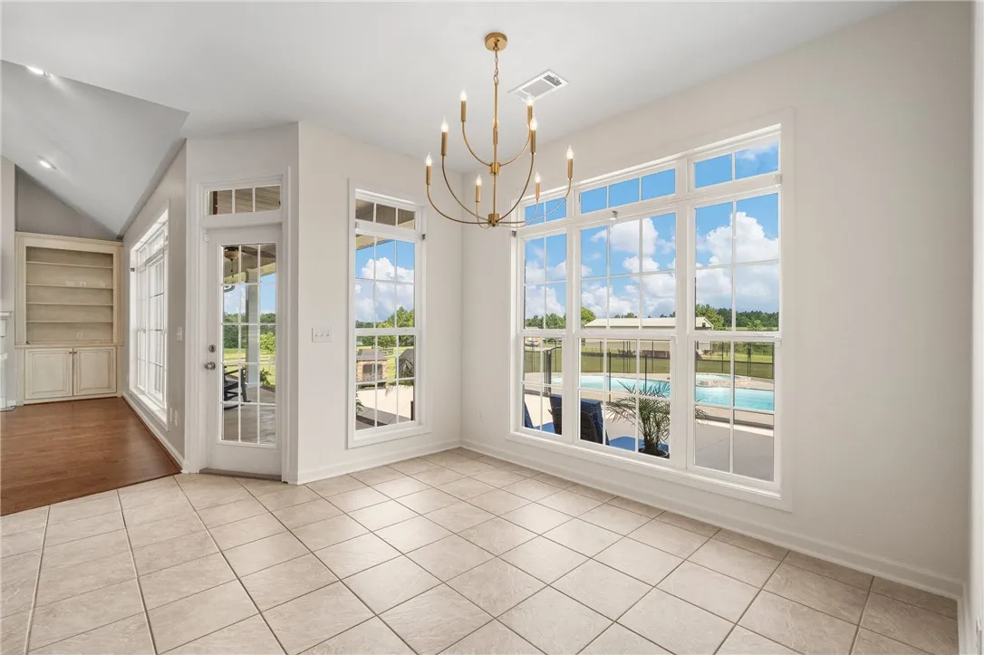 A spacious dining area offers inviting pool views through generous windows and built-in shelving.