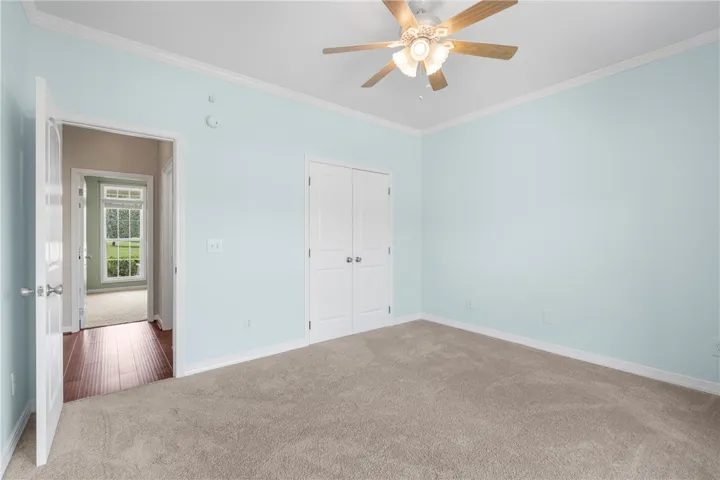 Comfortable bedroom offers soft carpeting and convenient closet space, perfect for quiet relaxation.