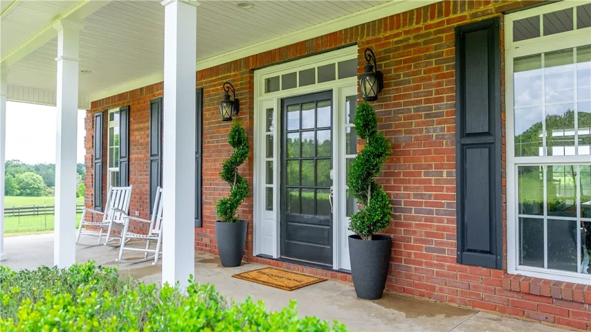 A classic brick exterior with a welcoming porch invites you to a serene country setting.