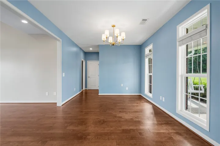 A refined dining space or living area with rich hardwood flooring and ample natural illumination.