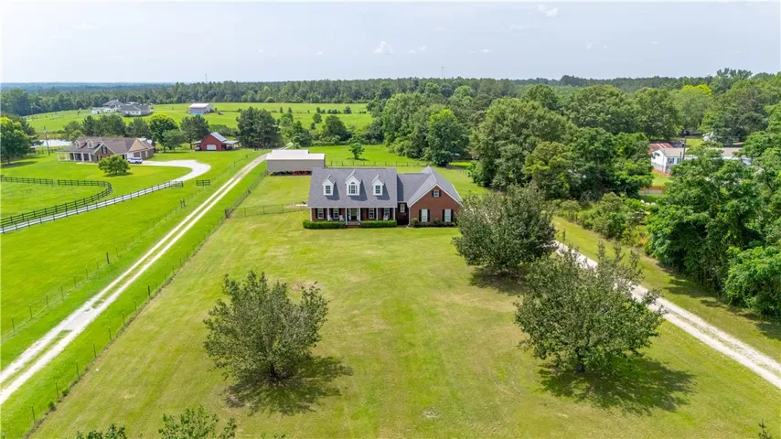 An inviting traditional residence set on a verdant landscape with a long, private driveway.