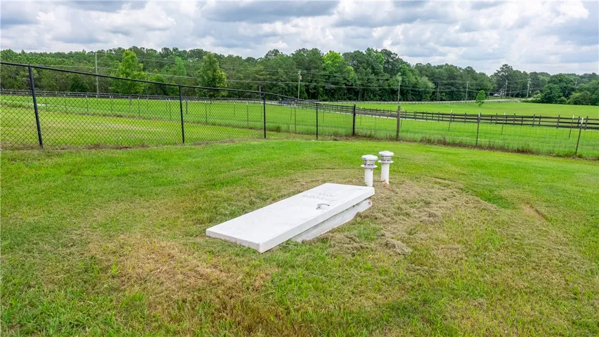 A verdant outdoor space bordered by sturdy fencing, offering open-air living possibilities.