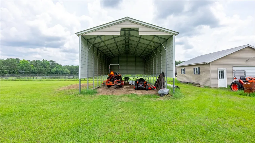 A spacious, open-air shed provides ample storage for outdoor equipment alongside a practical utility building.