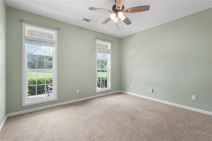 Two well-lit windows offer refreshing views of the verdant landscape, complementing the room's inviting atmosphere.